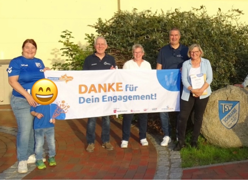 Ehrenamt überrascht - Personen mit Banner